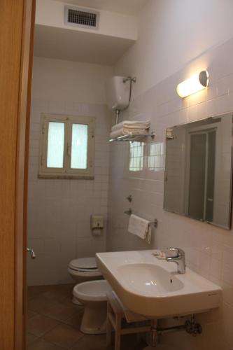 a bathroom with a sink and a toilet and a mirror at Hotel La Locanda Del Borgo in Casal Monastero