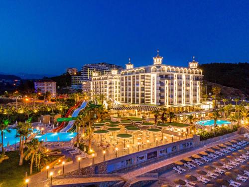 科纳克勒ARIA RESORT & SPA HOTEL Ultra All Inclusive的一座大型建筑,在晚上前设有一个游泳池