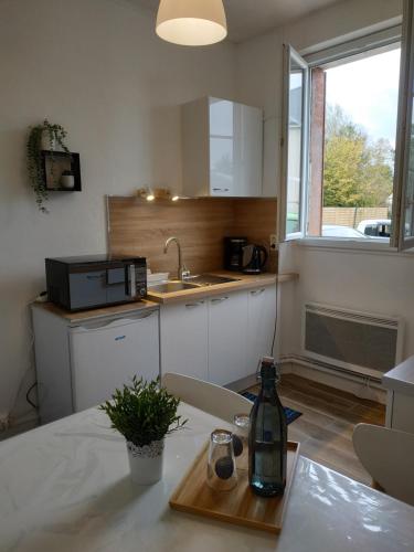 - une cuisine avec une table et une bouteille de vin dans l'établissement Le Ténor - Appartement - Parking gratuit, à Orléans