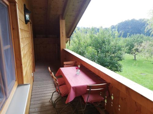 una mesa y sillas en el porche de una casa en Sonnenhub, en Irschenberg