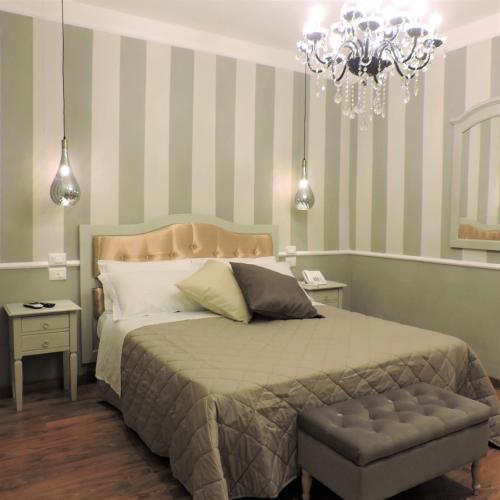 1 dormitorio con cama y lámpara de araña en Boutique Hotel Masolino, en Panicale