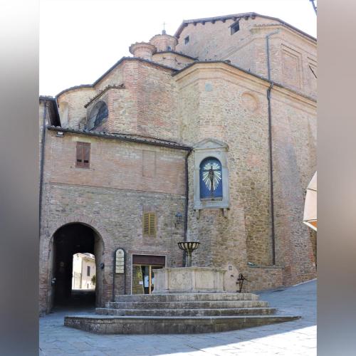 un gran edificio de ladrillo con un reloj. en Boutique Hotel Masolino, en Panicale