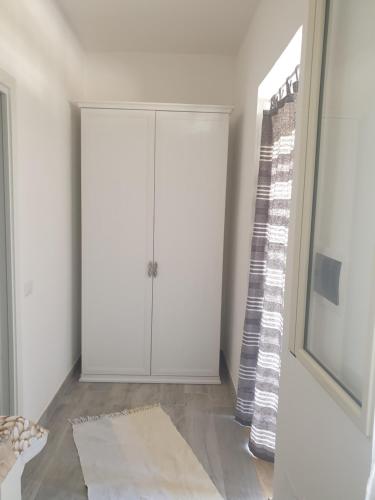 um quarto com um armário branco e uma janela em graziosa villetta III em Lampedusa