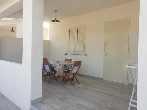 una cucina e una sala da pranzo con tavolo e sedie di graziosa villetta III a Lampedusa