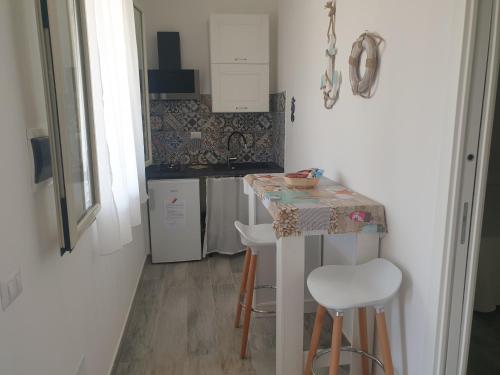 graziosa villetta III في لامبيدوسا: مطبخ صغير مع طاولة وكراسي
