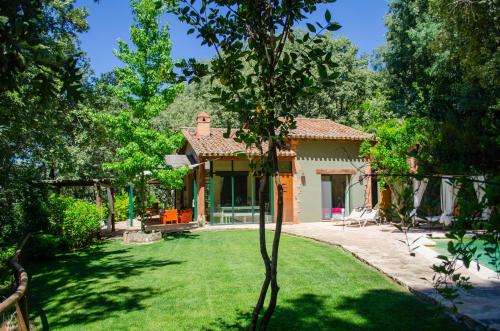 una piccola casa in un cortile con un prato di El Escondite De Pedro Malillo a Candeleda