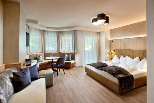 una camera d'albergo con 2 letti e una scrivania di Hotel Margit a Finkenberg