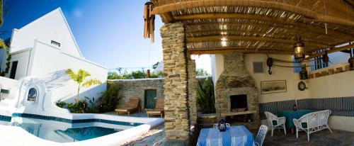 uma casa com uma piscina e um pátio em Tulbagh Travelers Lodge - Cape Dutch Quarters em Tulbagh