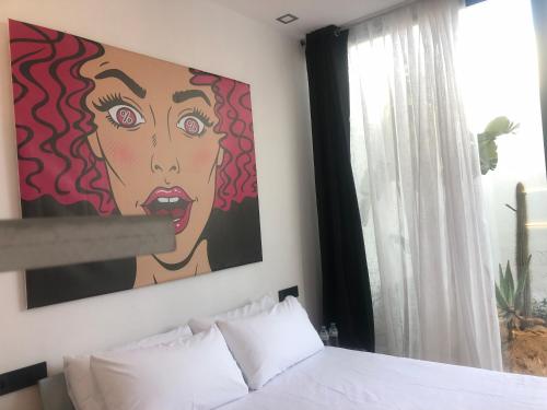 a bedroom with a painting on the wall at OM Hotels in Sant Francesc de s'Estany