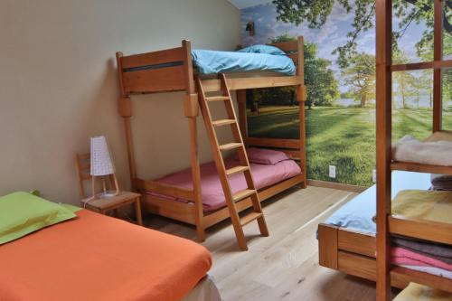 a room with two bunk beds and a window at La Malinette B&B, calme et authenticité in Mâlain