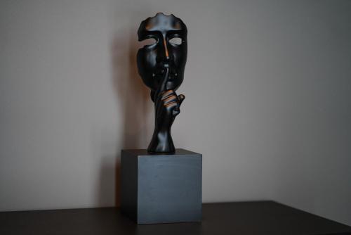a black statue sitting on top of a table at The Central View Boutique Hotel in Vlorë