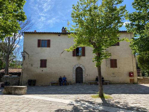 un edificio con un árbol delante de él en Window to Bagno Vignoni, en Bagno Vignoni