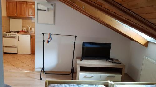 a room with a table with a tv and a kitchen at Studio apartman Ivana in Jajce