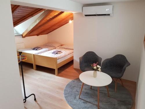 a bedroom with a bed and two chairs and a table at Studio apartman Ivana in Jajce