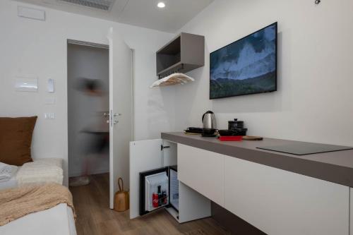 a white room with a desk and a bed at La Sirena Rooms in Giardini Naxos