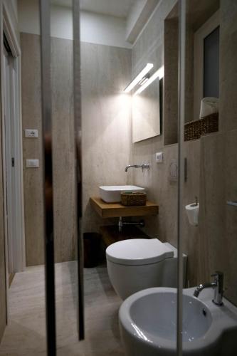 a bathroom with a toilet and a sink at La Sirena Rooms in Giardini Naxos