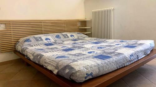a bed with a blue and white quilt on it at La Moretta in Fano