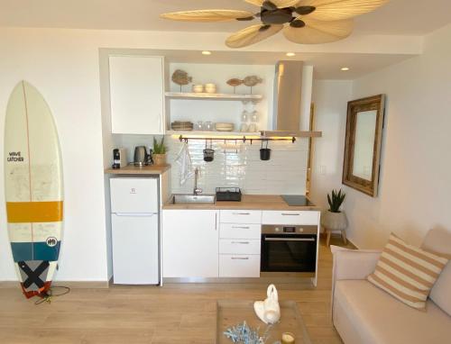 a living room with a kitchen and a surfboard at Corfu, Glyfada, Sea la vie apartment in Glyfada