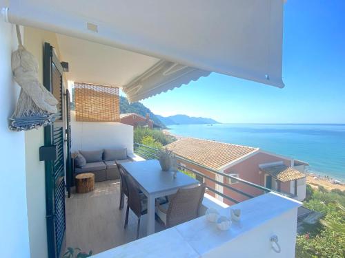 een balkon met een tafel en uitzicht op de oceaan bij Corfu, Glyfada, Sea la vie apartment in Glyfada