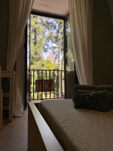a bedroom with a bed and a large window at Duomo Treehouse in Catania