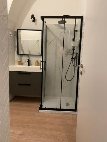 a bathroom with a glass shower with a sink at Duomo Treehouse in Catania