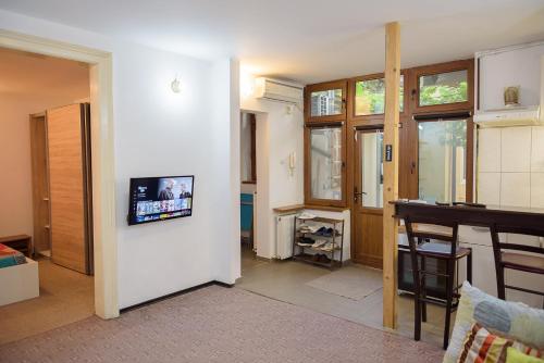 a living room with a tv on a wall at Center Walking Apartment and Room in Bucharest