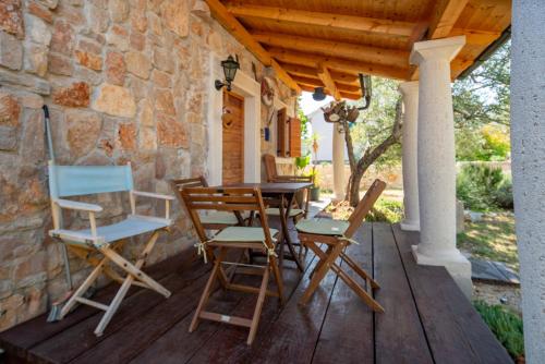 a wooden table and chairs on a wooden deck at Villa Flaveico in Pašman