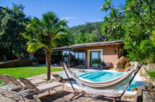 a resort with a hammock and a house at Landscape Villas - El Escondite De Pedro Malillo in Candeleda