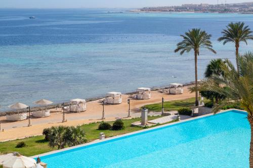a swimming pool next to a beach and the ocean at The Makadi Spa Hotel - Couples Only 18 Years Plus in Hurghada