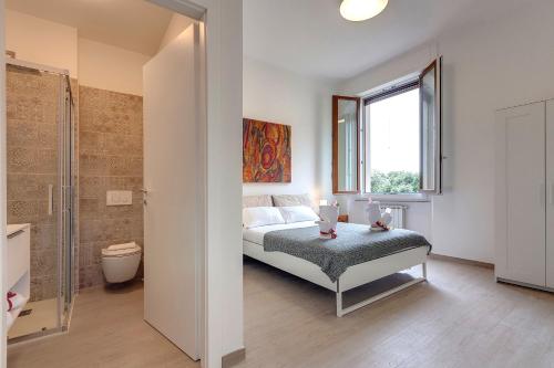 a bedroom with a bed and a bathroom with a shower at Mamo Florence - Cavour Apartments in Florence