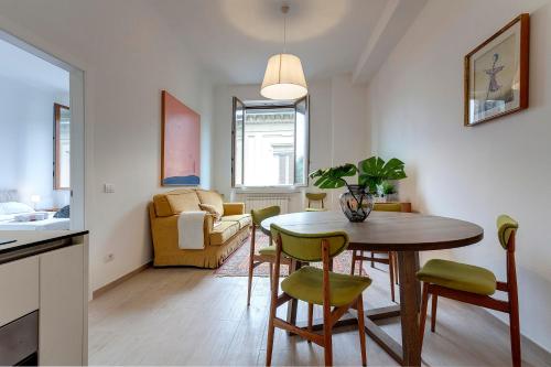 uma cozinha e sala de estar com mesa e cadeiras em Mamo Florence - Cavour Apartments em Florença