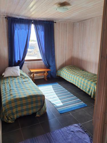 Habitación pequeña con 2 camas y ventana en Tiinan Tallin talo, en Seinäjoki