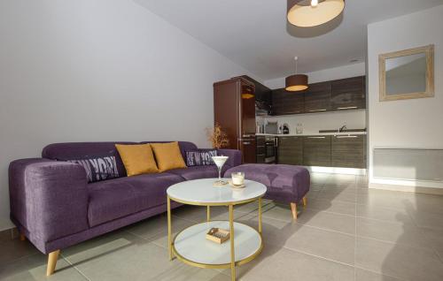 sala de estar con sofá púrpura y mesa en Mini-villa mitoyenne de type F2 proche Golfe de Lava en Appietto