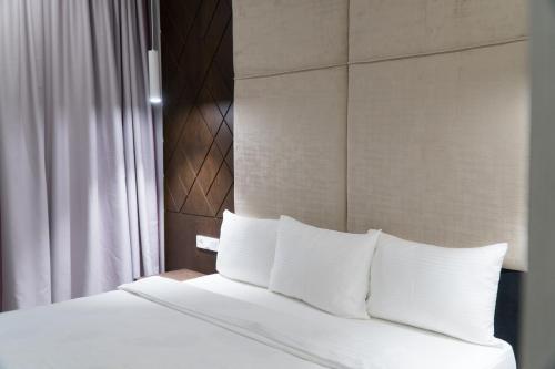 a bed with white pillows in a hotel room at East Palace Hotel in Almaty