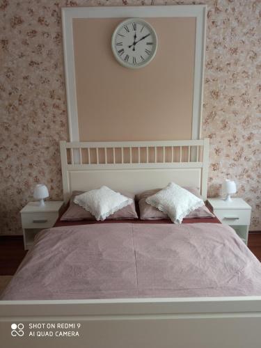 a bedroom with a bed with a clock on the wall at UBYTOVÁNÍ NA SPRÁVNÉM MÍSTĚ in Znojmo