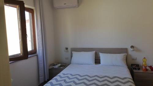 a bedroom with a bed with a blue and white comforter at Affittacamere Sos Ninnitteddos in Torpè