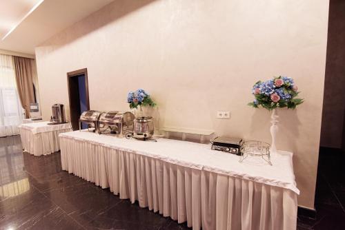 a room with tables and chairs with flowers on the wall at East Palace Hotel in Almaty