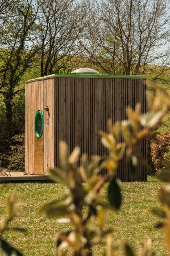 a small wooden building with a green circle on it at Domaine d'Escapa in Estipouy