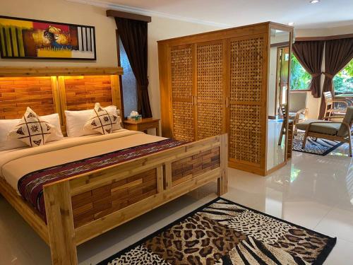 a bedroom with a large wooden bed in a room at Jepara Marina Beach Bungalows in Jepara