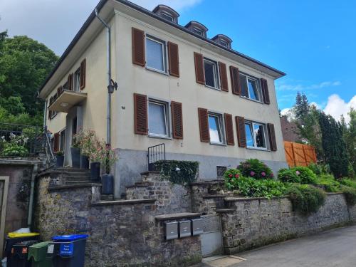 ein Haus auf einer Steinmauer mit einigen Pflanzen in der Unterkunft Ferienwohnungen Stella, Adrián in Saarbrücken