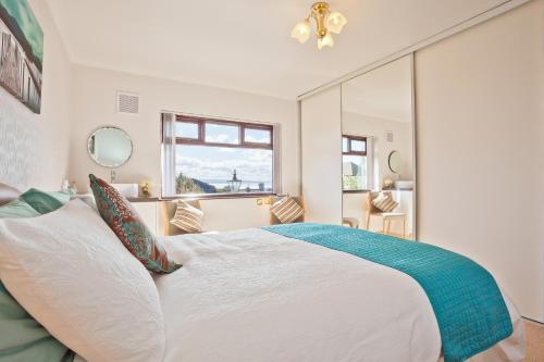 a bedroom with a large bed and a large mirror at Kents Bank Holiday - Pet Friendly with Bay Views in Grange Over Sands