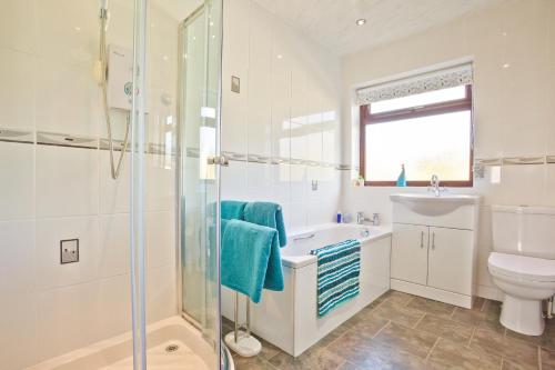 a bathroom with a shower and a toilet and a sink at Kents Bank Holiday - Pet Friendly with Bay Views in Grange Over Sands
