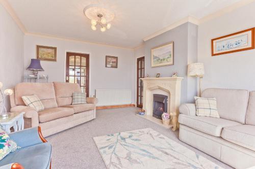 a living room with two couches and a fireplace at Kents Bank Holiday - Pet Friendly with Bay Views in Grange Over Sands