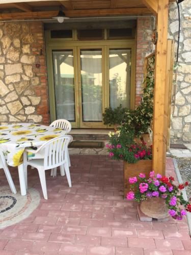 a patio with a table and chairs and flowers at Casavacanze Da Cri in Ponte dʼArbia
