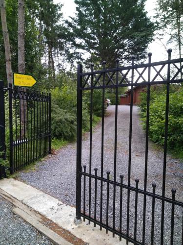 a black wrought iron gate with a sign on it at Au Paradou du Bûcheron Adults only in Lessive
