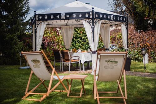 a gazebo with a table and chairs in a yard at Guest House Veronika in Kočevje