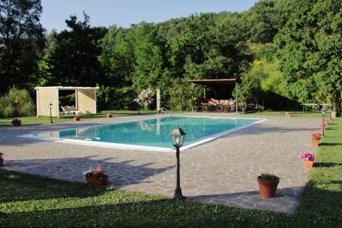 uma piscina com um poste de luz na relva em La Valle De' Medici em Barberino di Mugello