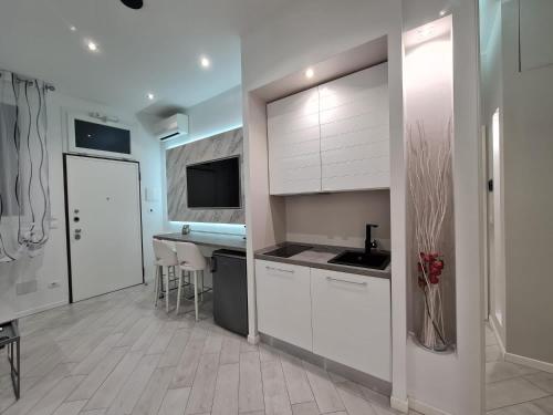 uma cozinha com armários brancos e uma bancada em SUITE VILLA LAURA em Bolonha