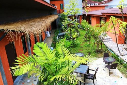 a resort with tables and chairs and a thatched roof at 2 Home in Chalong 