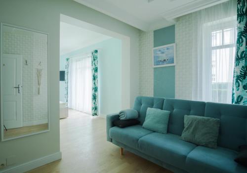 a living room with a blue couch and a mirror at roomsy guest house in Sopot